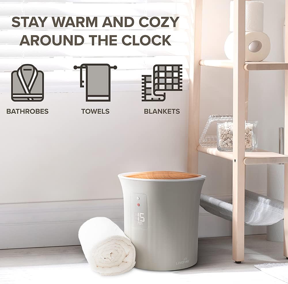 A white towel rack holding a towel, accompanied by a sign that reads Stay warm and cozy around the clock